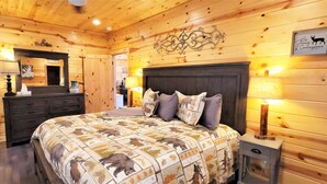 Une chambre confortable dans un chalet en bois, avec un lit, une commode et un miroir.