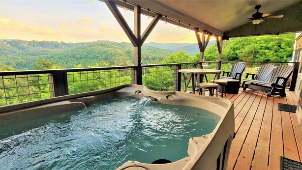 A hot tub on a wooden deck with a view of a forested mountain range. - Panoramic Views, LED Hot Tub, King Suite, Wi-Fi, Minutes to Downtown Gatlinburg (Gatlinburg)