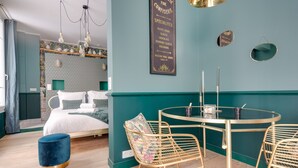 Una habitaci ón moderna con una cama, una mesa redonda con sillas y una pared con un cartel de menú.
