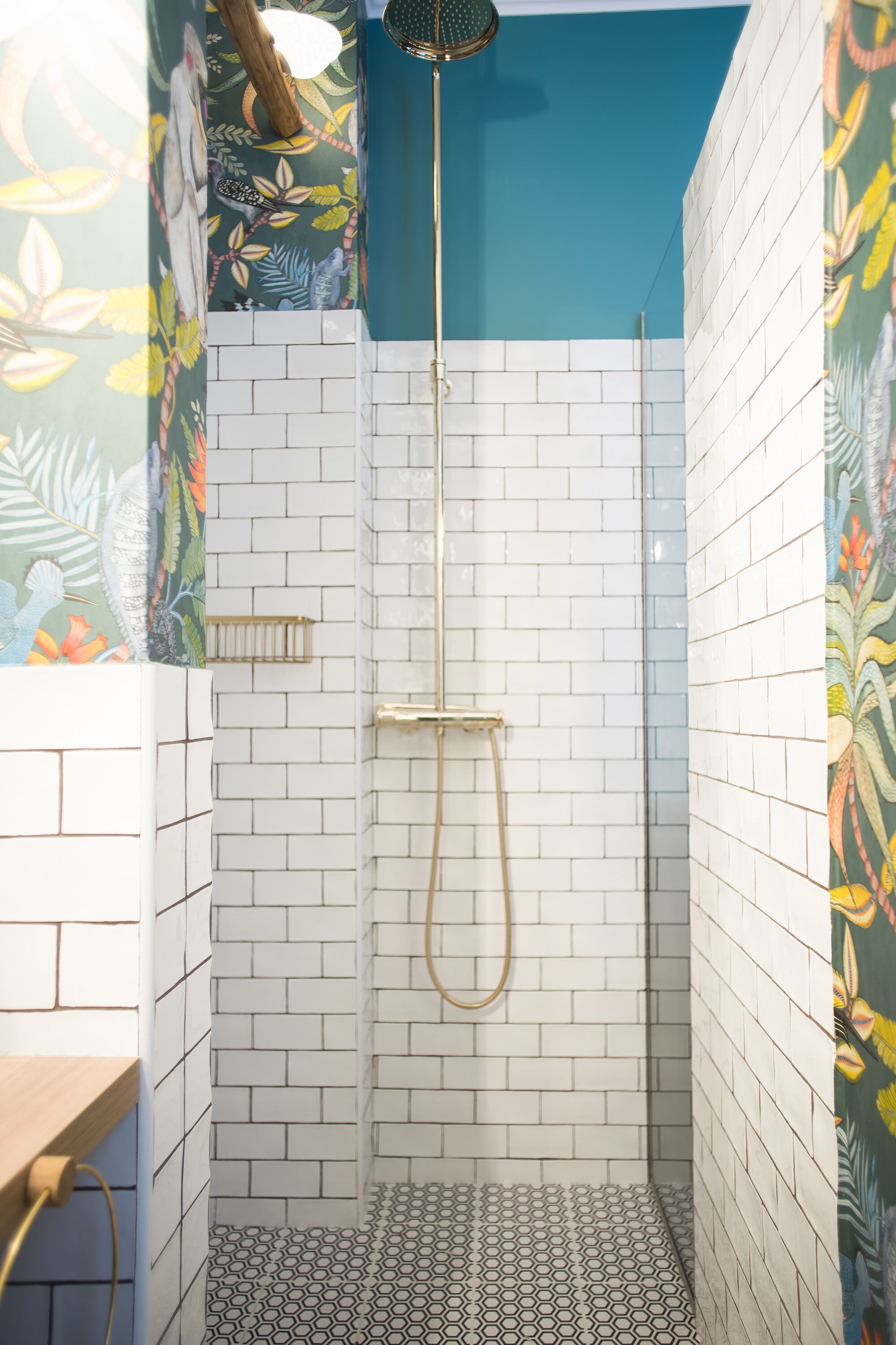Une douche avec des carreaux blancs et un mur d’accent bleu.
