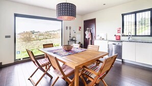 Eine moderne Küche mit großem Fenster, einem Holzespeisetisch und Stühlen.