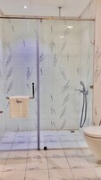 Cabezal de ducha tipo lluvia y artículos de higiene personal gratuitos