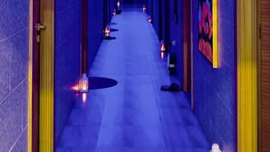 A long, narrow hallway with doors on both sides, illuminated by blue and purple lighting. - BW Suites & Spa (Manama)