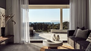 Uma sala de estar moderna com um sofá, uma mesa de centro e vista para o mar.