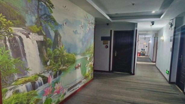 A corridor with a mural of a waterfall and lotus flowers, a door with a sign, and a hallway leading to another room. - Jinhui Hotel (Guangyi Affiliated Hospital Respiratory Medicine Center Tanwei Subway Station) (Guangzhou)