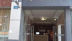 A hotel entrance with a reception desk, a chandelier, and a sign indicating the address. - Jinhui Hotel (Guangyi Affiliated Hospital Respiratory Medicine Center Tanwei Subway Station) (Guangzhou)