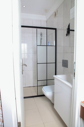 A bathroom with a shower, toilet, and sink. - Garden Hill Hotel (Istanbul)