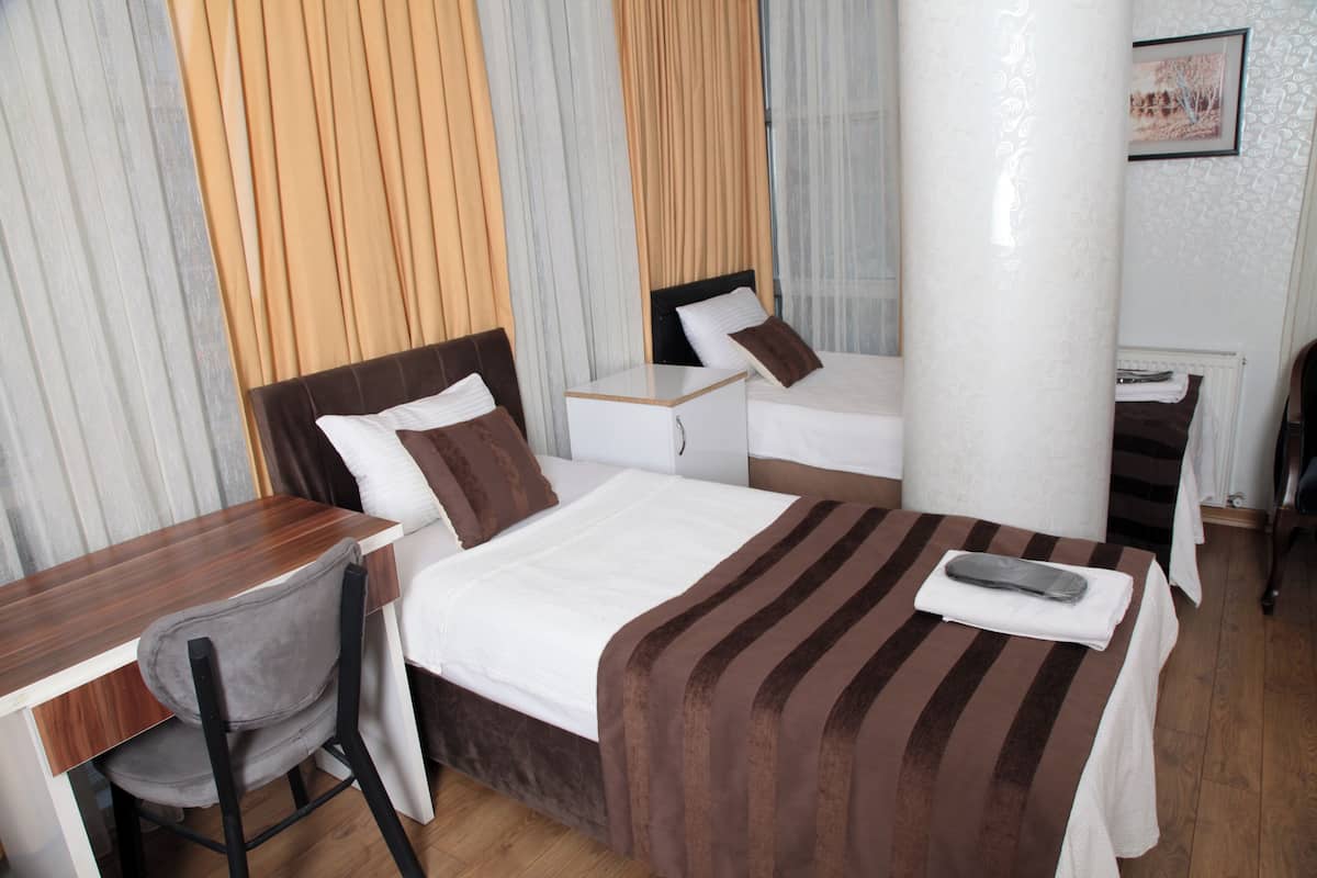A hotel room with a bed, a desk, and a chair.