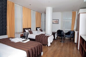 A hotel room with two beds, a desk, a chair, and a large window with curtains. - Garden Hill Hotel (Istanbul)