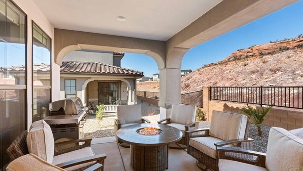 Une terrasse extérieure avec des meubles en osier et un foyer.