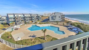 A beachfront hotel with a swimming pool, multiple balconies, and ocean views. - Experience oceanfront living at Shipwatch Villas 1209 in North Topsail Beach! (North Topsail Beach)