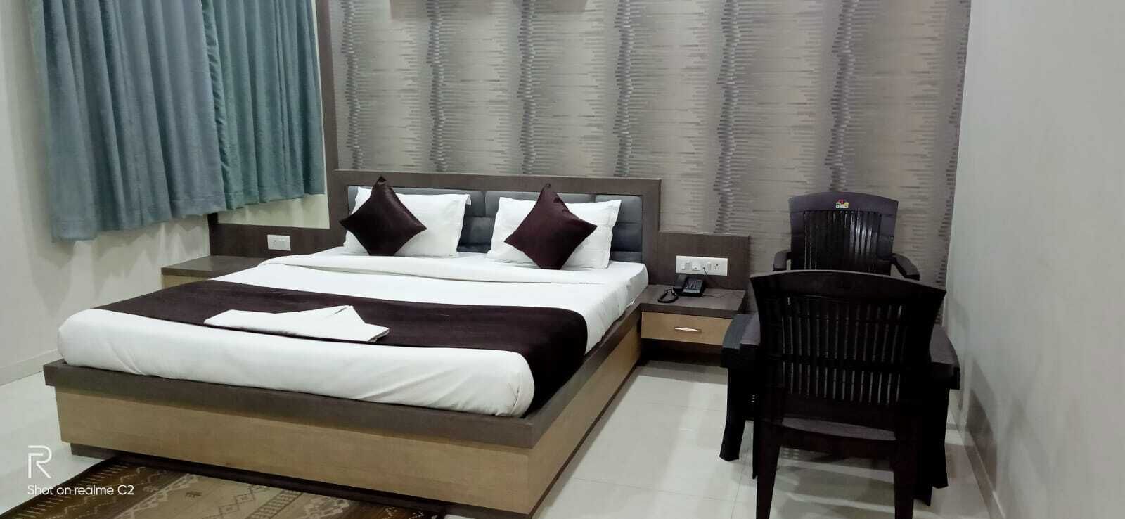 A modern bedroom with a large bed, a desk, and a chair.