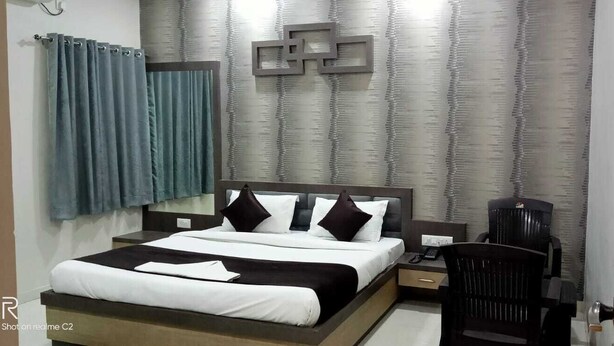 Quarto de hotel moderno com uma cama grande, uma escrivaninha e uma cadeira.