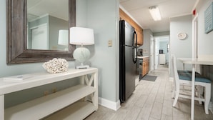 A modern kitchen with a black refrigerator, white cabinets, and a wooden countertop. - Great Oceanfront 1 Bedroom in Desirable North Ocean City (Ocean City)