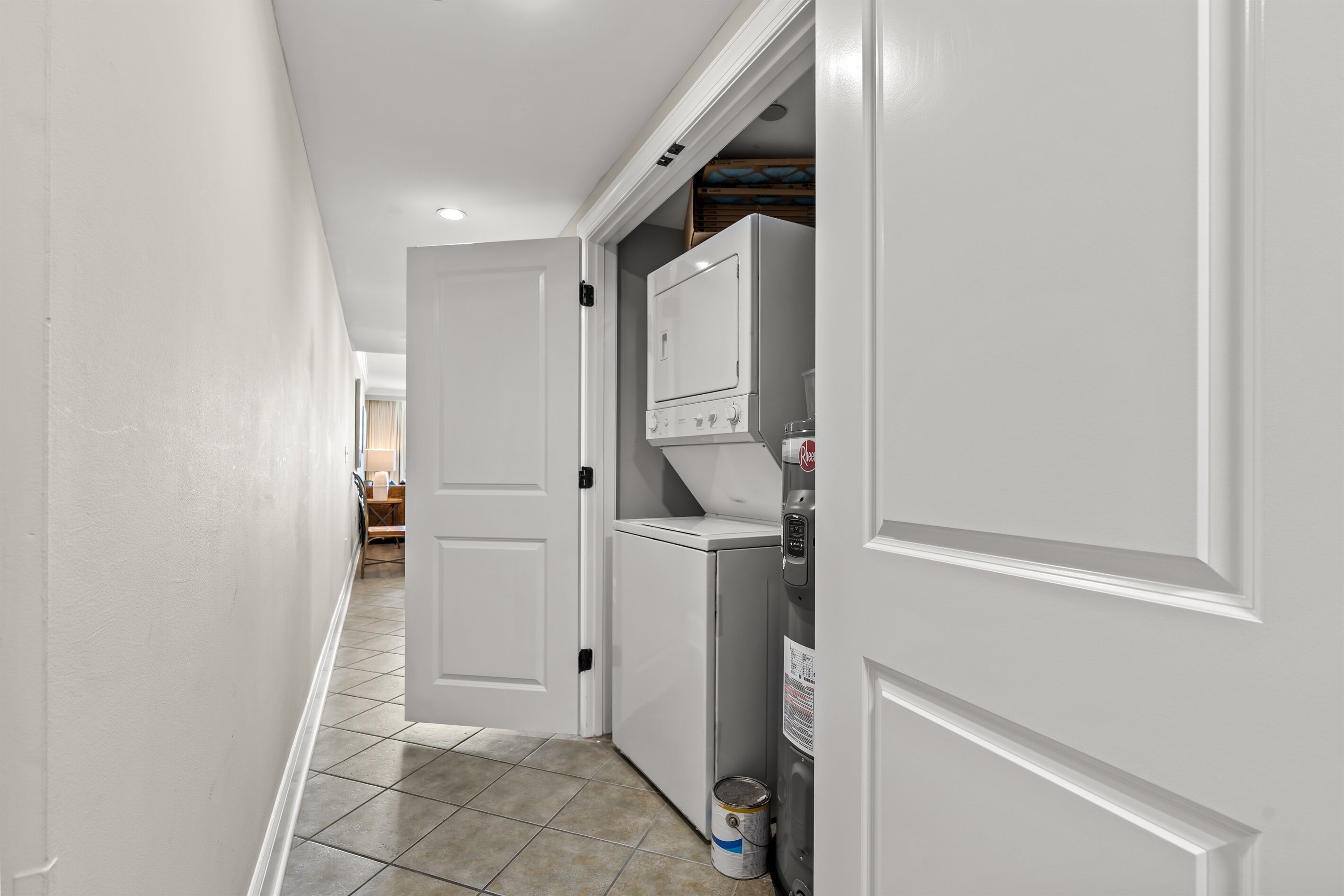 A narrow hallway with a white door leading to a laundry area.