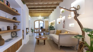 Una sala de estar acogedora con sofá, una mesa de centro y estanterías de madera con adornos.