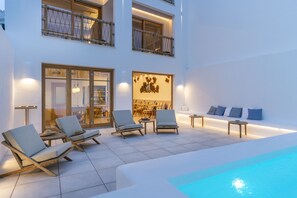 Una piscina al aire libre, sombrillas, sillones reclinables de piscina