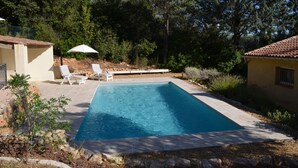 A rectangular swimming pool with a tiled deck, surrounded by a landscaped garden with trees and shrubs. - Provençal villa (Le Thoronet)