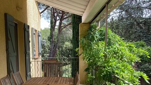 A wooden table and chairs on a balcony with a view of greenery and trees. - Provençal villa (Le Thoronet)