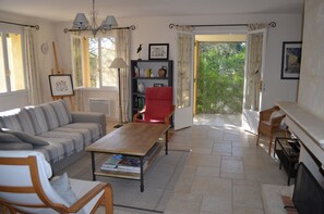 TV connectée, cheminée, livres, chaîne hi-fi