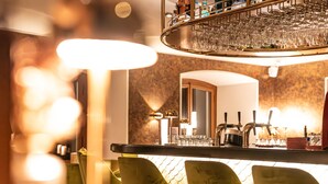 A bar area with a counter, multiple taps, and a wine rack. - Hotel Porto Sofie (Gottlieben)