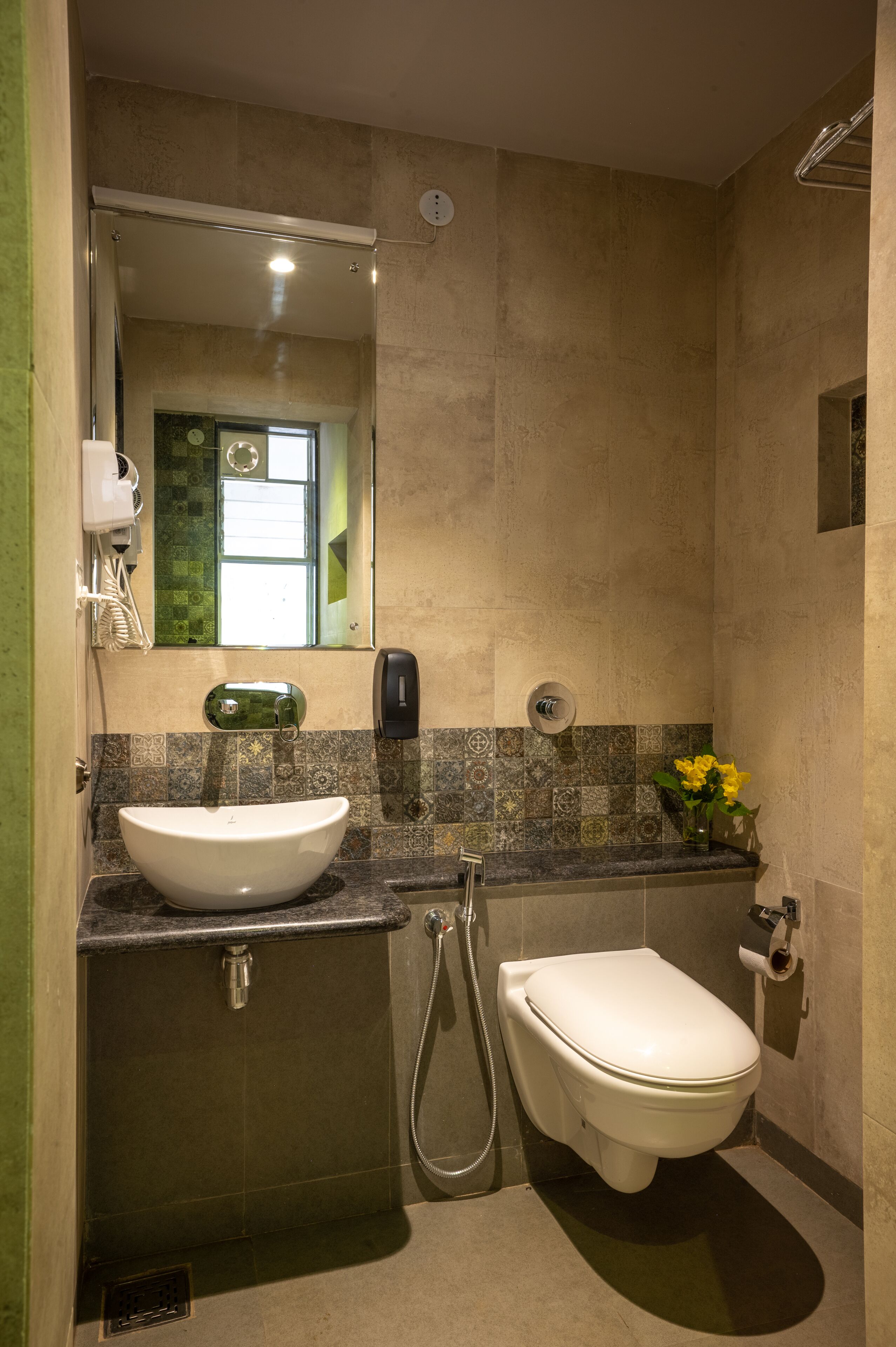 A bathroom with a sink, toilet, and a mirror.
