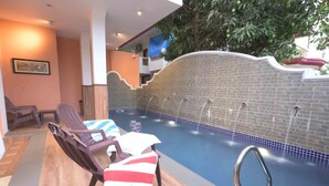 An indoor swimming pool with lounge chairs and a tiled wall. - Foxoso Vega, Colva, Goa (Margao)