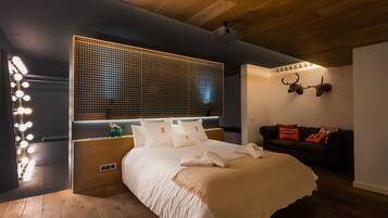 Un dormitorio moderno con una cama grande, un tocador con luces, techo de madera y un adorno de pared.