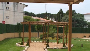 A garden pathway with a pergola structure, surrounded by a low hedge and a row of stones. - Modern Apartment - Gardens/Pool/WIFI/AIRCON/PARKING - D302, Apartment Riells Blau D302 in L'Escala -... (L'Escala)