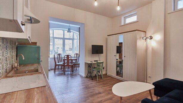 Eine moderne Küche mit eingebautem Herd, eine Essecke mit Holzkästen und ein großes Fenster, das für natürliches Licht sorgt.