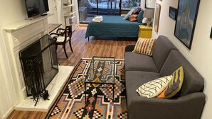A living room with a fireplace, a sofa, a coffee table, and a patterned rug.