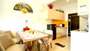 A compact living space with a dining area, kitchenette, and a small bathroom. - Lcp 1 (Genting Highlands)