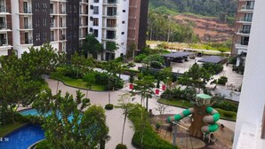 A residential building with multiple balconies, a landscaped courtyard with a playground, and a swimming pool. - Lcp 1 (Genting Highlands)