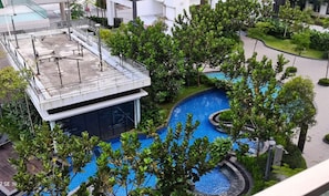 A rooftop pool area with a modern design, surrounded by lush greenery and a covered seating area. - Lcp 1 (Genting Highlands)