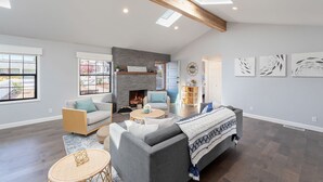 Ein großzügiges Wohnzimmer mit Kamin, einer Couch, einem Couchtisch und einem Bücherregal.