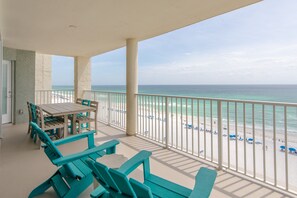 A balcony with a view of the beach and ocean.