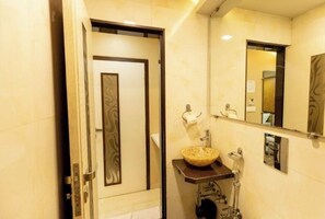 Bathroom features a large mirror, a central vanity with a bowl sink, and a towel rack.