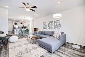 A modern living room with a grey sectional sofa, a coffee table, and a floor lamp.