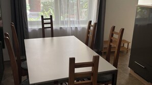 Ein Essbereich mit einem rechteckigen Tisch und sechs Holzstühlen mit gepolsterten Sitzen.