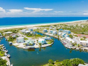 A coastal resort with multiple buildings, a marina, and a beach.