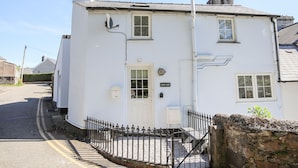 A white two-story building with a white door, windows, and a satellite dish. - Bryn Coed (Porthmadog)