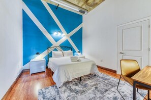 A bedroom with a bed, bedside tables, a desk, and a chair. - Sosuite | 2BR Apt w W/D, Gym, On-Site Restaurant (Philadelphia)