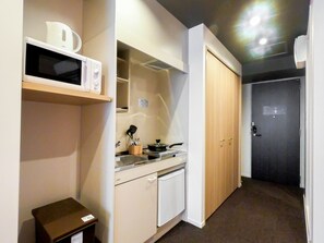 Compact kitchen area with a stovetop, sink, and refrigerator.