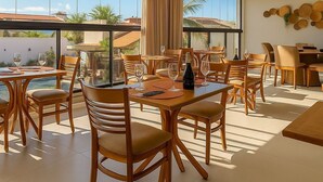 Un amplio comedor con mobiliario de madera y ventanas grandes que ofrecen vistas al exterior.