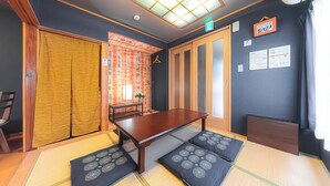 A tatami mat room with a low table, sliding doors, and a small table with a plant. - HOTEL Kita-Shinagawa (Tokyo)