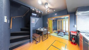A compact hotel room with a staircase, a dining area, a fire extinguisher, and a view of the hallway. - HOTEL Kita-Shinagawa (Tokyo)