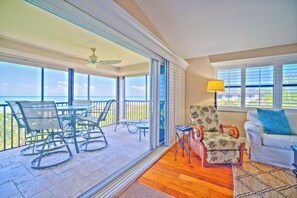 A spacious balcony with a view of the ocean, furnished with chairs and a table. - Tarpon Beach 112 offers the BEST Beach View! Stunning, Top Floor, Corner Unit (Sanibel)