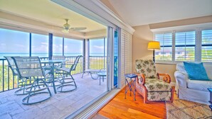 A spacious balcony with a view of the ocean, furnished with chairs and a table. - Tarpon Beach 112 offers the BEST Beach View! Stunning, Top Floor, Corner Unit (Sanibel)