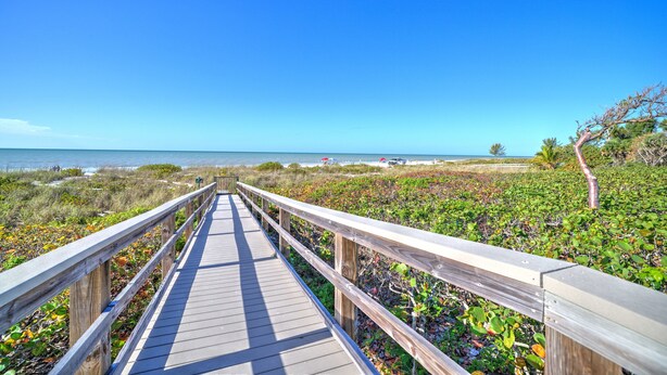 A wooden boardwalk leading to a beach with clear skies. - Tarpon Beach 112 offers the BEST Beach View! Stunning, Top Floor, Corner Unit (Sanibel)