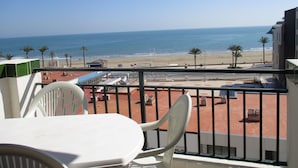 A balcony with a view of the beach, palm trees, and a clear sky. - Peñíscola Playa Inmomart (Peñiscola)